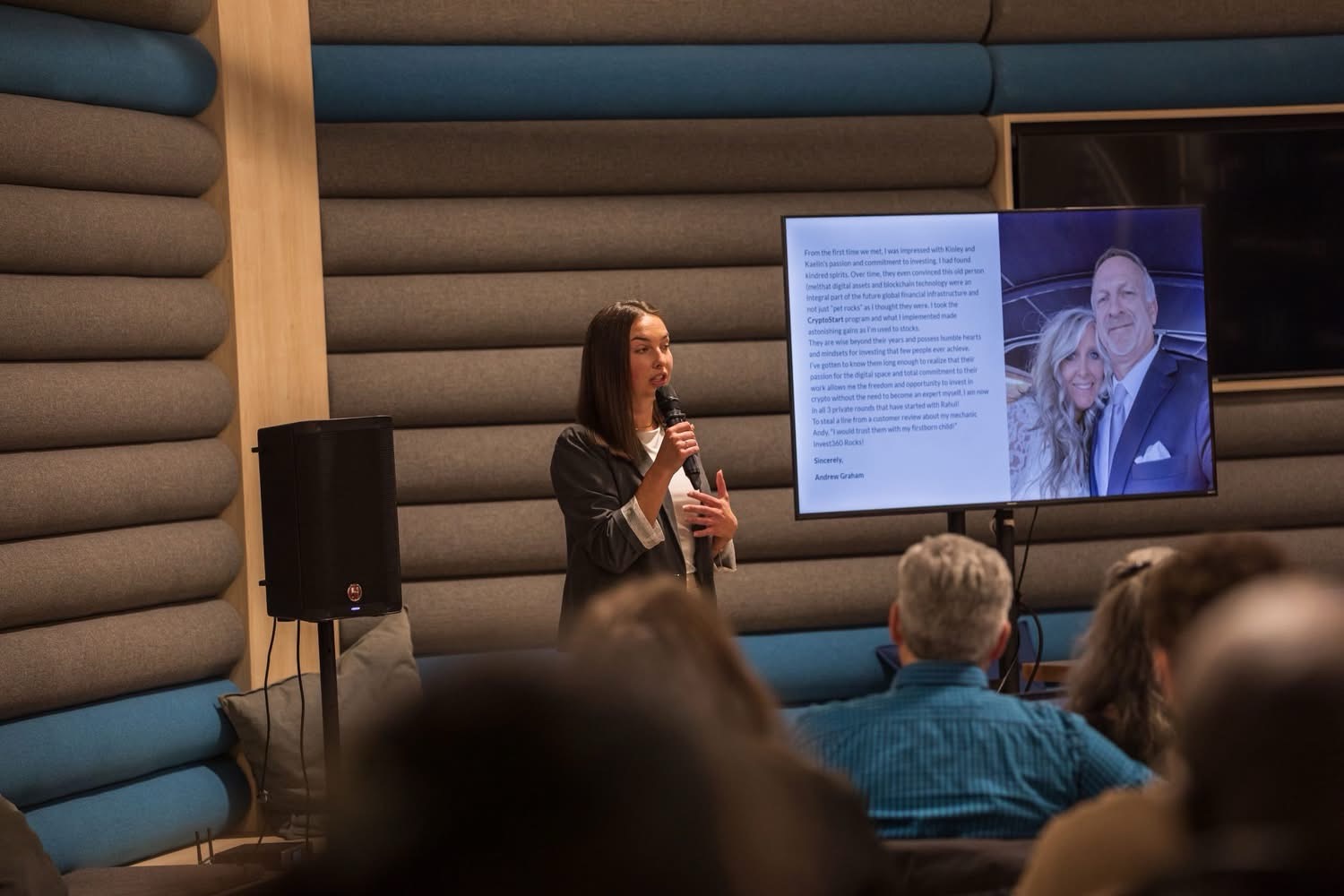 Kinley Coe presenting a client testimonial on stage