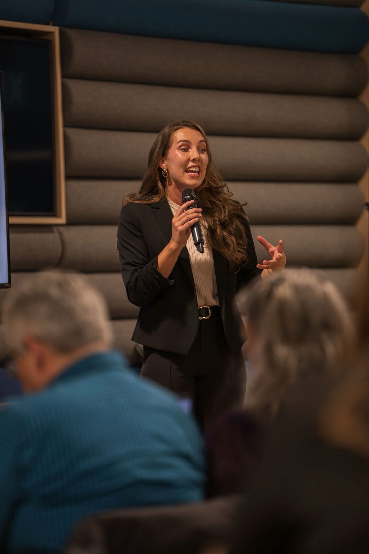 Kinley Coe speaking to a room of attendees